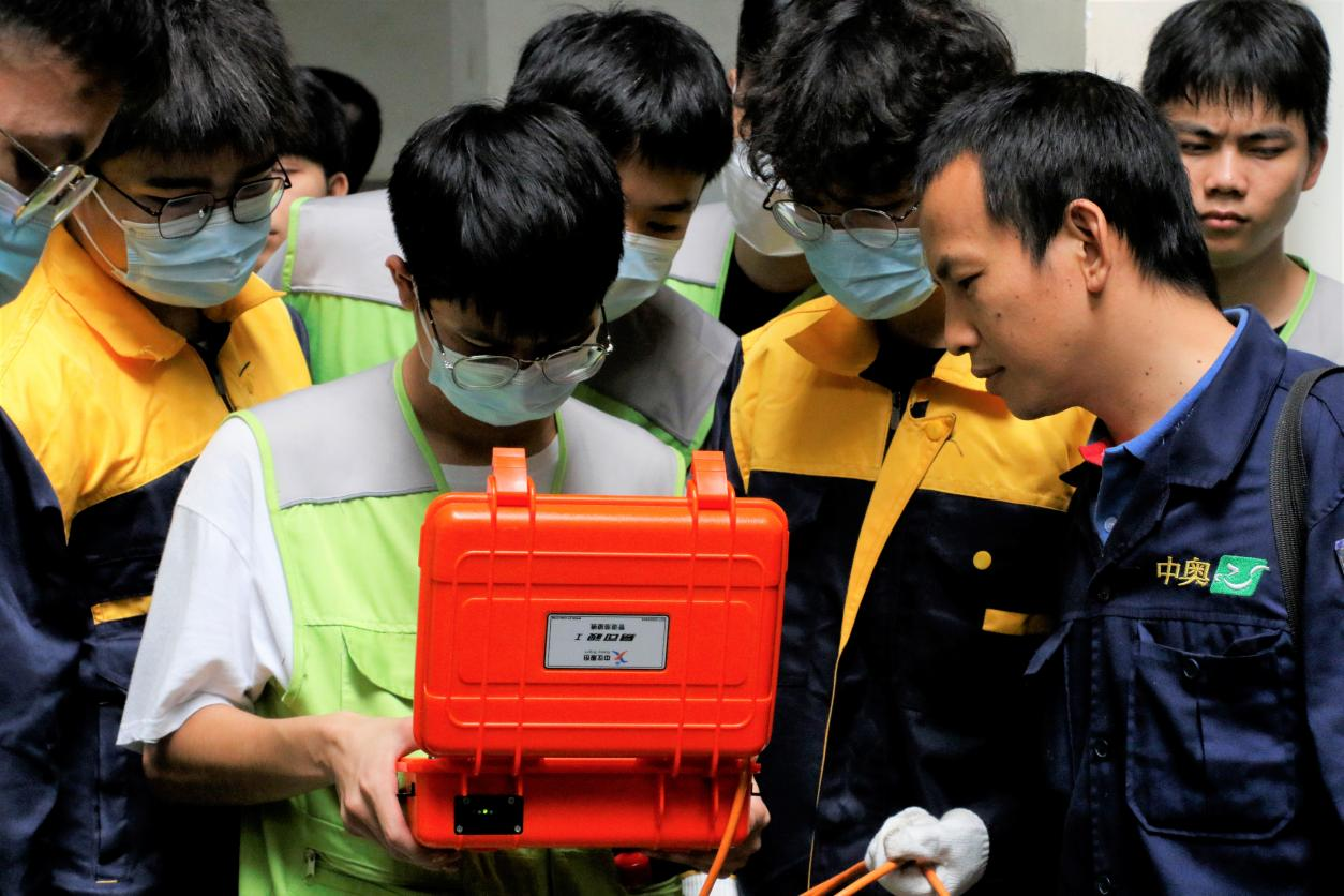 志愿者向社區(qū)管理人員展示潛望鏡觀測管道內(nèi)側(cè)圖像