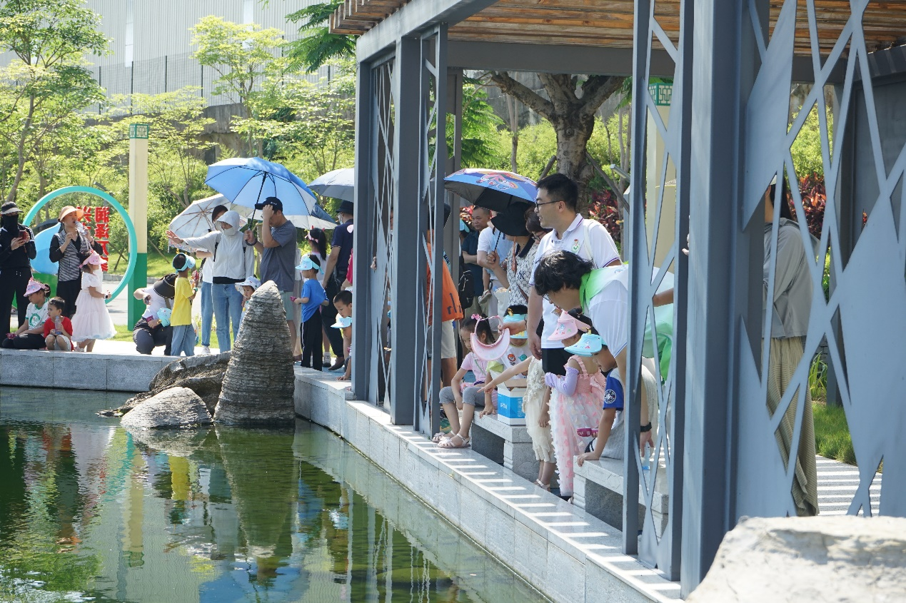 志愿者指引著小朋友和家長們參觀污水凈化的工藝