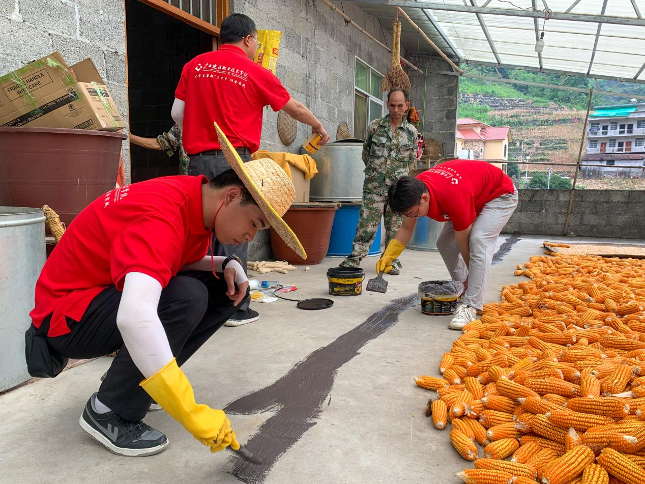 實踐團成員在房頂裂縫處涂抹防水涂料