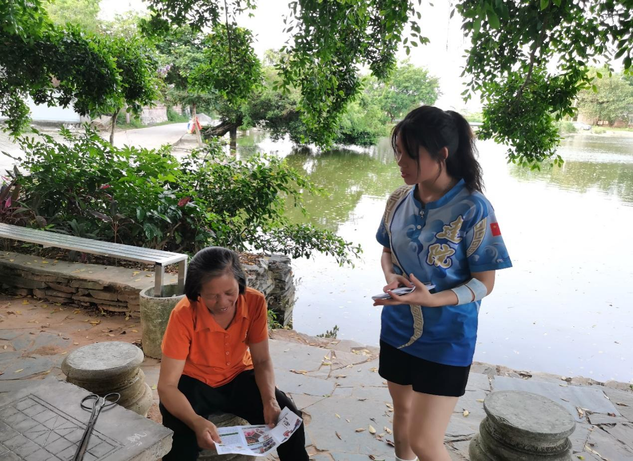 實(shí)踐團(tuán)成員在發(fā)放宣傳手冊(cè)并講解龍獅運(yùn)動(dòng)