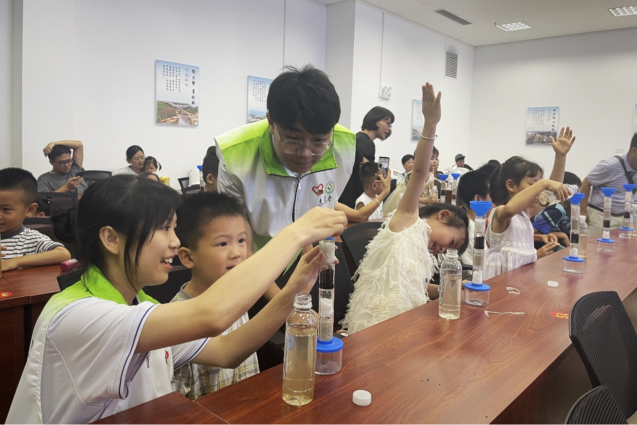 “創(chuàng)智聯(lián)`志愿者在科普廳與小朋友一起完成凈水小實(shí)驗(yàn)