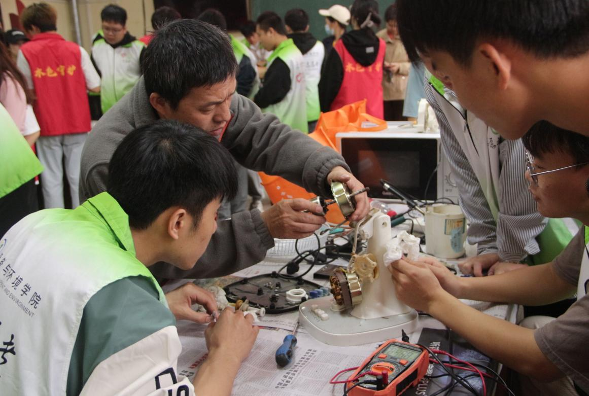 指導(dǎo)老師帶領(lǐng)志愿者進(jìn)行家電維修