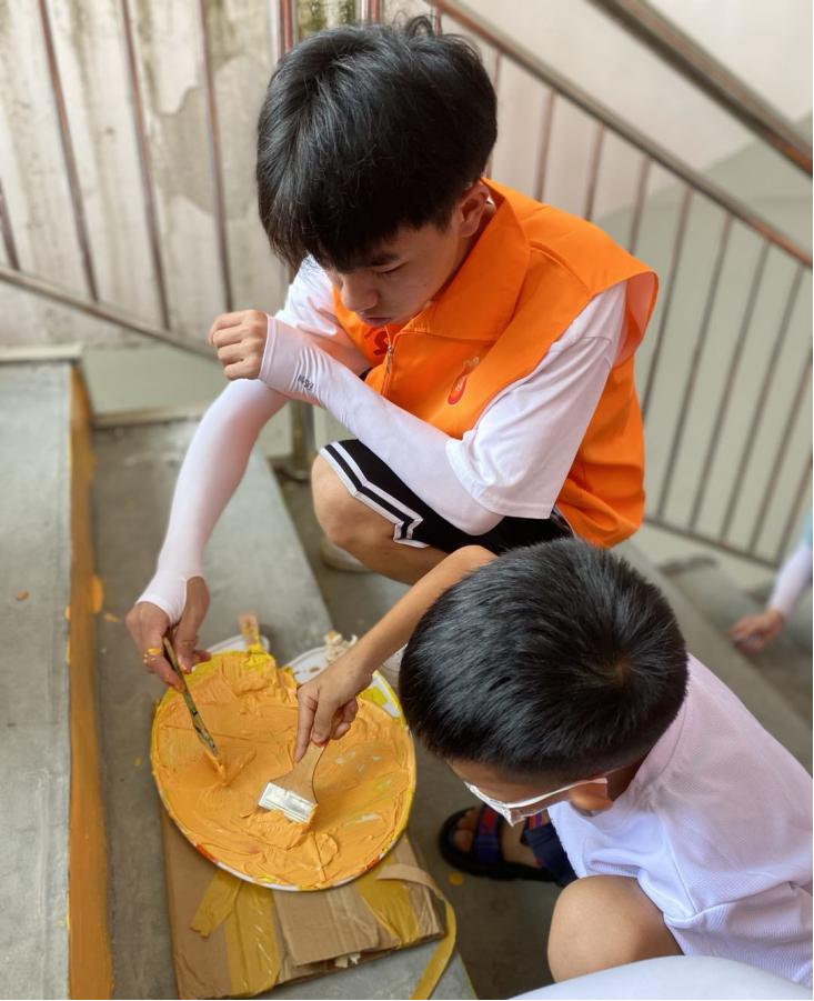 志愿服務團成員與小朋友一起進行階梯繪畫