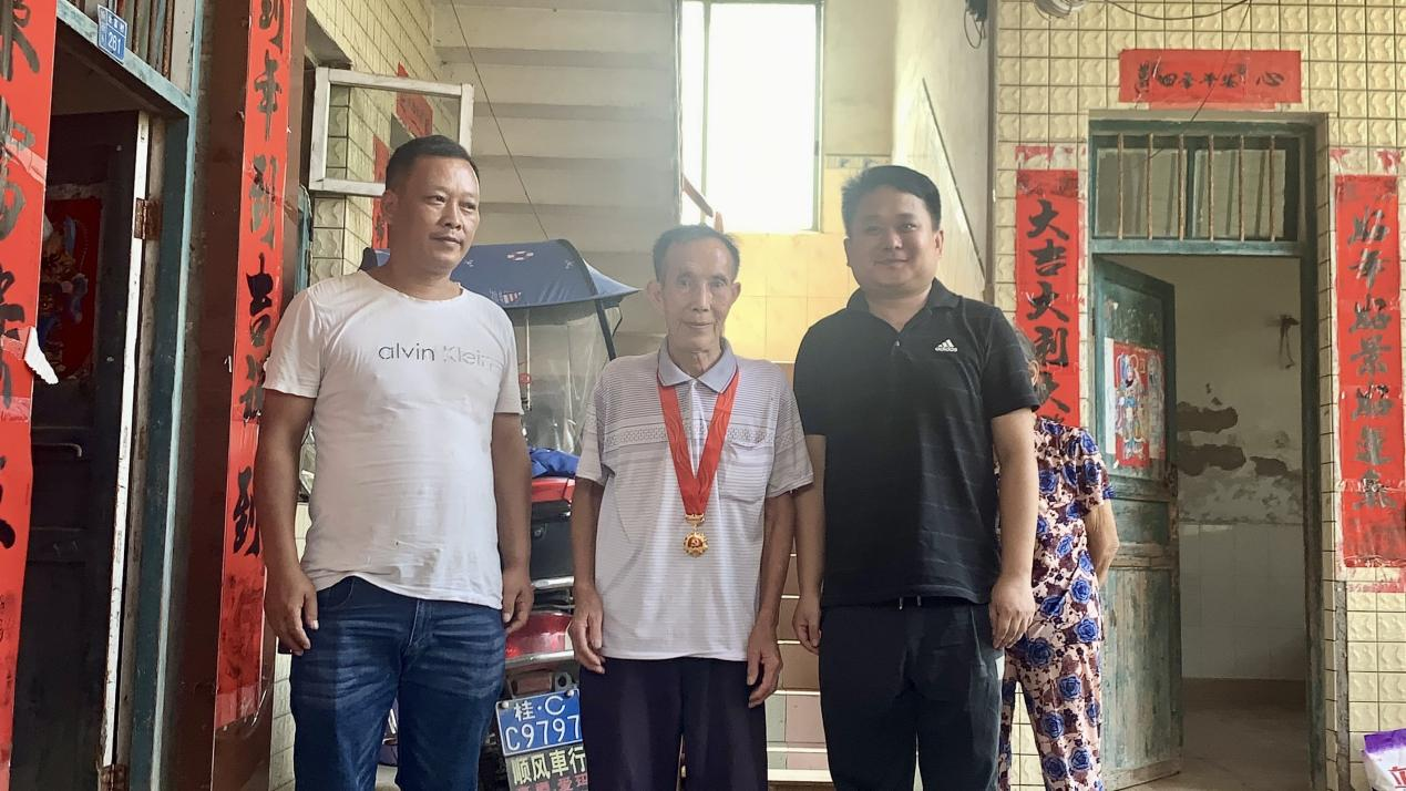 老黨員王化珍（中）接受“光榮在黨50年”紀念章頒發