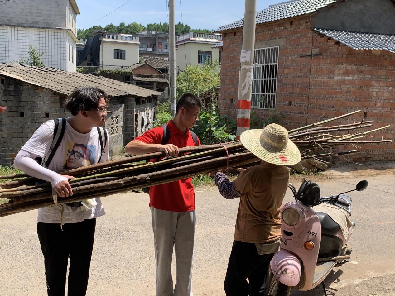 觀察團(tuán)成員幫助村民搬運重物