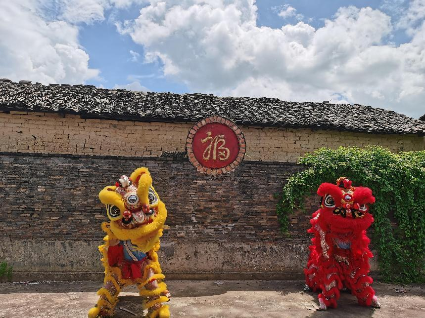 實(shí)踐團(tuán)成員在村落古建筑處舞獅