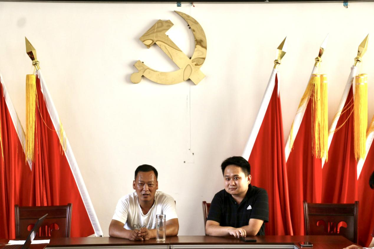 永富村黨支部書記王波（左）介紹鞏固脫貧攻堅成效的經驗做法